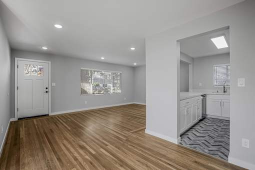 A room with wooden flooring and white walls.