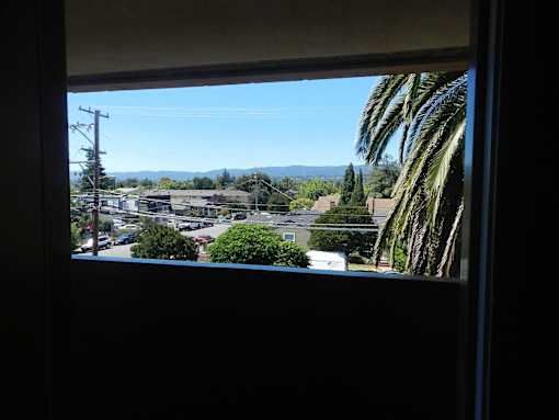 A view from a window looking out at a residential street.