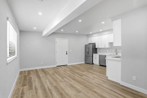 A kitchen with white cabinets and a refrigerator.
