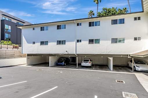 A white building with a parking garage in front of it.