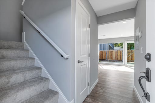 a white door leading to a staircase in a house