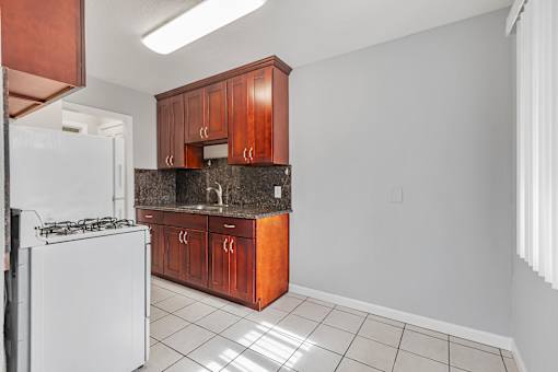 A kitchen with white appliances and brown cabinets.