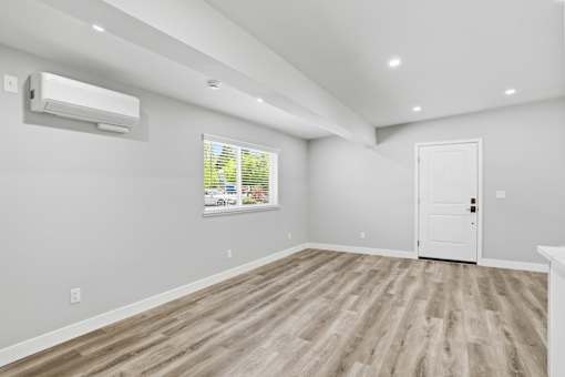 A room with a white door and a window with blinds.