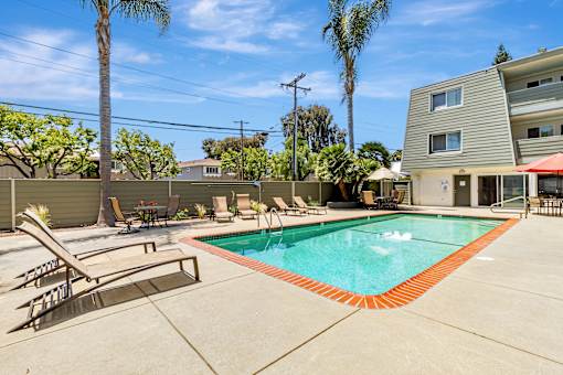 A pool with a red border and a slide in the middle.