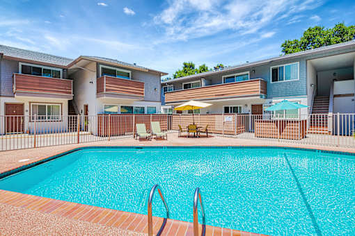 A swimming pool in front of apartment buildings.