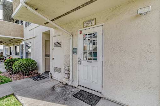 A white door with a sign that says Laundry Room.