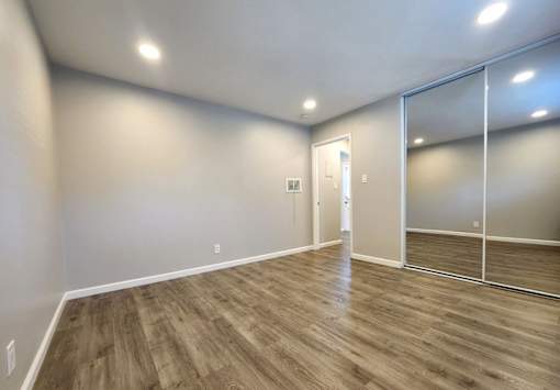 A room with wooden flooring and a glass door.
