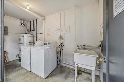 A white industrial machine sits in a room with a white door.