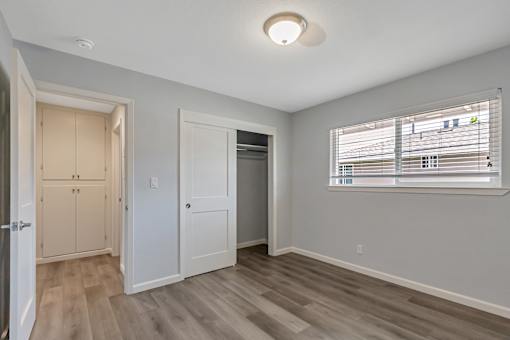 A room with a window and a wooden floor.