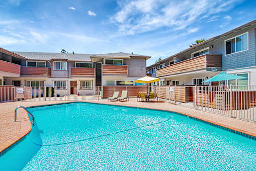 A swimming pool in front of apartment buildings.
