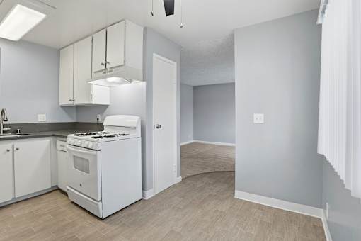 A kitchen with white appliances and cabinets.