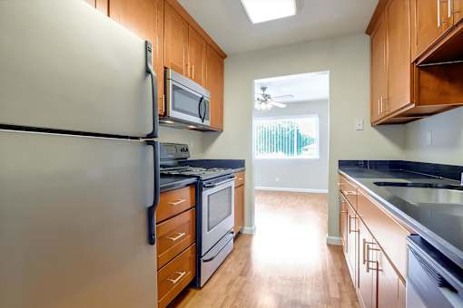 A kitchen with a white refrigerator and wooden cabinets.