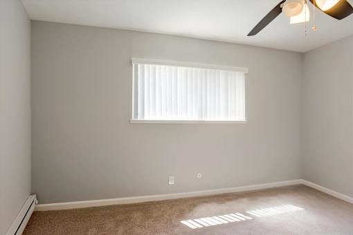 A room with a window and a ceiling fan.
