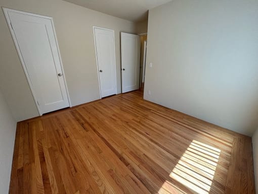 a living room with wood floors and white walls