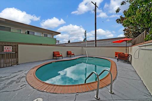 A small pool with a red tile border and a metal ladder.
