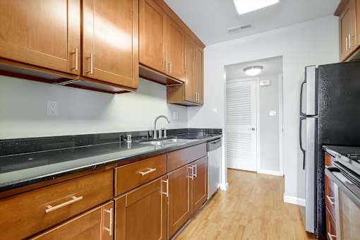 A kitchen with wooden cabinets and black appliances.