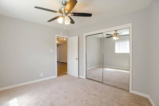 A room with a ceiling fan and a sliding glass door.