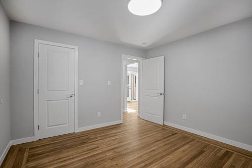 A room with two doors and a wooden floor.