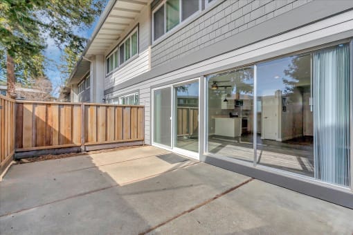 a patio in front of a white unit with glass doors