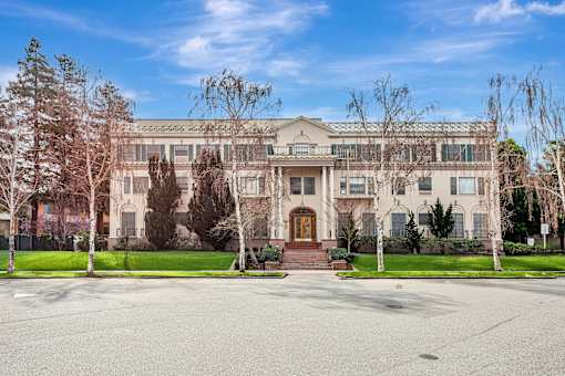 A large, two-story building with a front porch and a brown door.