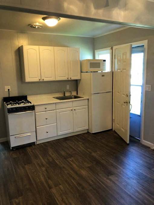 A kitchen with white appliances and cabinets.