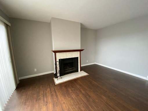 a living room with a fireplace and wooden floors