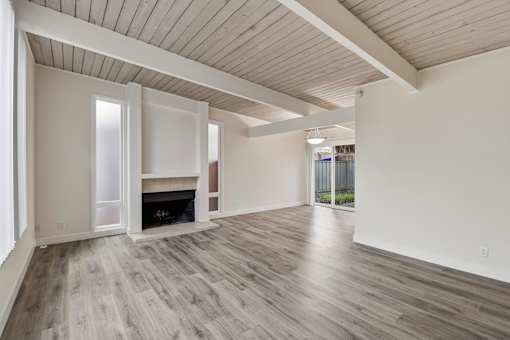 A room with a fireplace and sliding glass doors.
