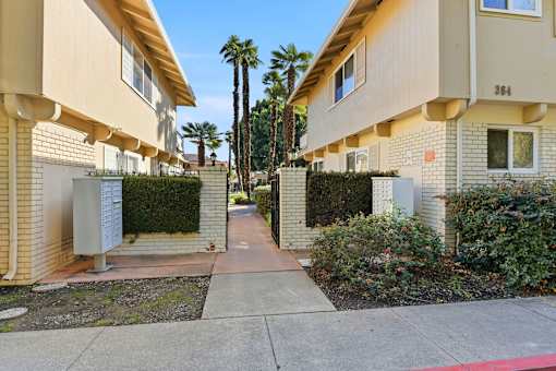 A row of houses with a sidewalk in front.