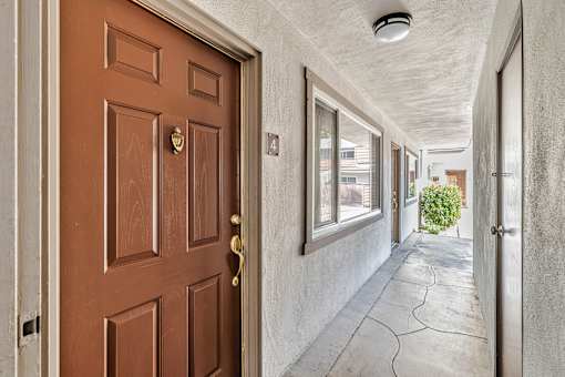 A brown door with a gold handle is on the left and a white door on the right.