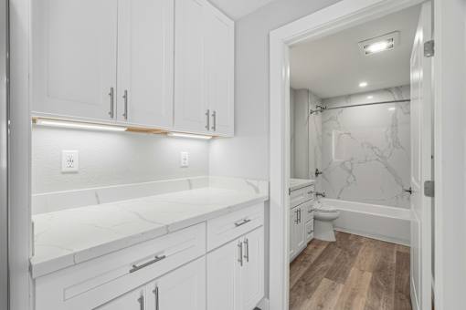 A white bathroom with a marble toilet and sink.