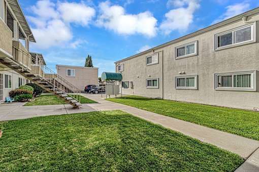 A sunny day at a residential area with apartment buildings and green lawns.