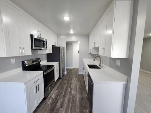 a kitchen with white cabinets and stainless steel appliances