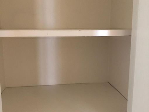 a small room with a shelf on the wall