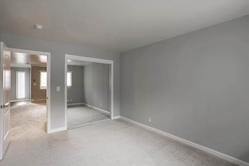 A large empty room with a carpeted floor and white walls.