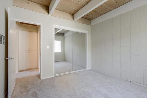 A room with a white tile wall and a carpeted floor.