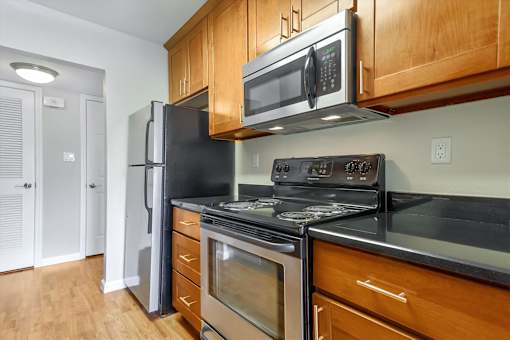 A kitchen with a black refrigerator, stove, and oven.