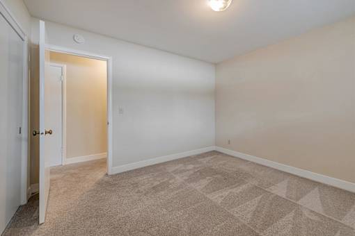 A room with a carpeted floor and a door.