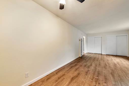 A room with wooden flooring and white walls.