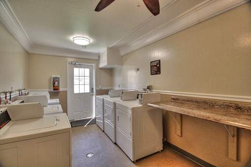 A laundry room with white appliances and a window.