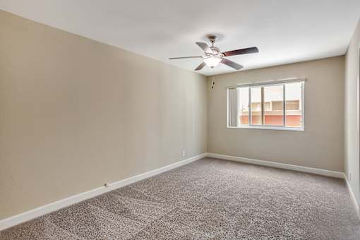 A room with a ceiling fan and a window.