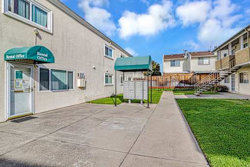 A rental office is located in a building with a green awning.