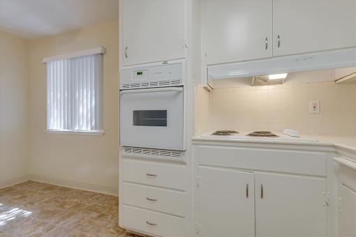 A kitchen with white cabinets and a microwave oven.
