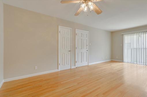 A room with a ceiling fan and two doors.