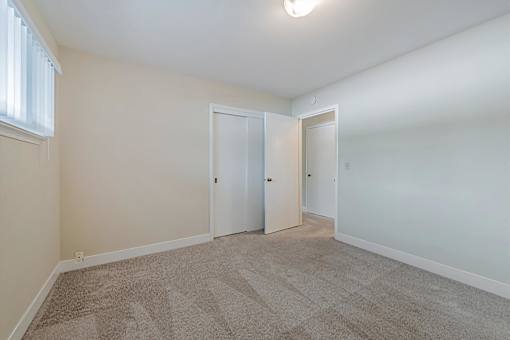 A room with two doors and a carpeted floor.