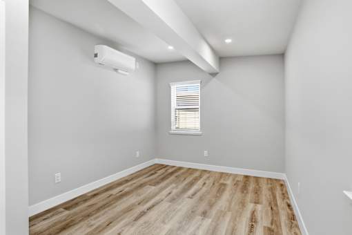 A room with a window and wooden flooring.