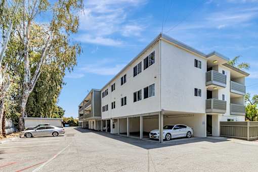 A white building with a car parked in front.