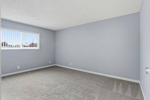 A room with a window and carpeted floor.