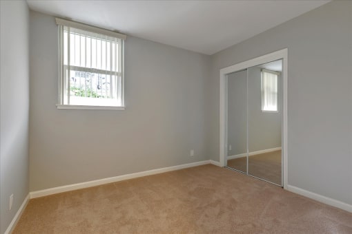A room with a carpeted floor and a sliding glass door.