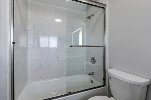 a white bathroom with a shower and a toilet