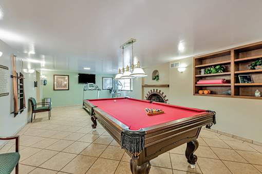 A pool table is in the middle of the room.